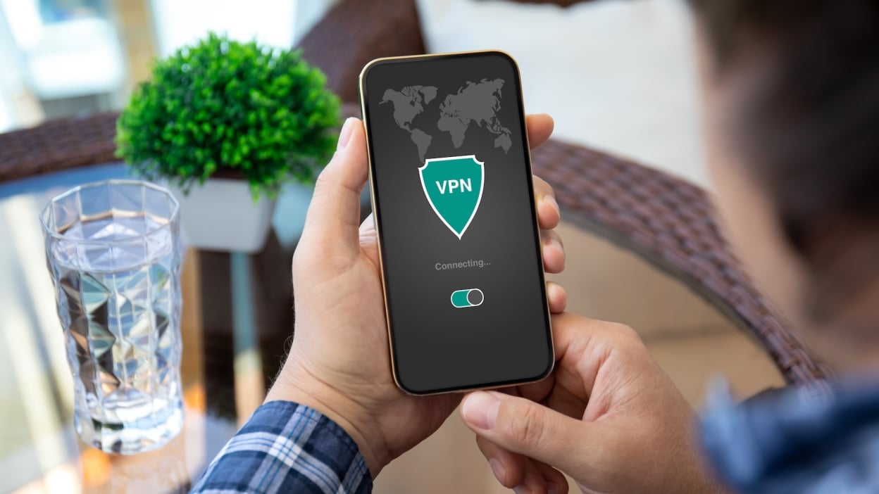 Man holding phone with VPN logo showing 